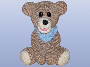 Gehäkelter brauner Teddybär mit blauem Halstuch, sitzend