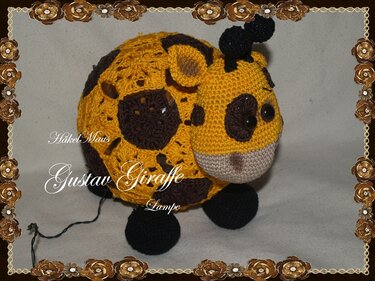 Gelb-braune gehäkelte Giraffe als Amigurumi-Lampe mit rundem Körper und sichtbarem Kabel