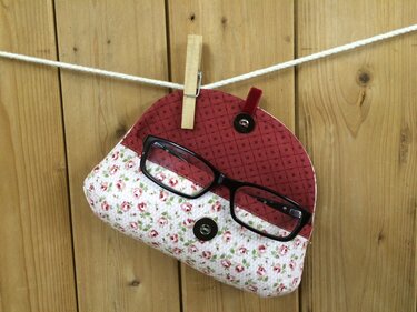 Genähtes Stoffbrillenetui mit Rosenmuster und schwarzer Brille an Wäscheleine