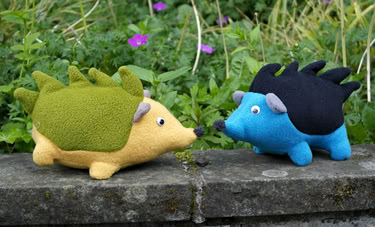 Zwei gen	e Stoffigel in Gr
-Gelb und Blau-Schwarz, gegenerstehend auf einer Mauer