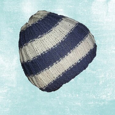 Gestrickte blau-weiß gestreifte Mütze vor hellem Hintergrund