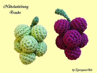 Zwei gehäkelte Trauben in Grün und Lila aus einzelnen Kugeln mit kleinem Stiel