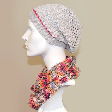 Seitenansicht einer Schaufensterpuppe mit grauer Slouch-Mütze mit Lochmuster und buntem Loopschal