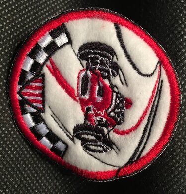 Runder bestickter Aufnäher mit stilisiertem Rennwagen, Zielflagge und rotem Rand