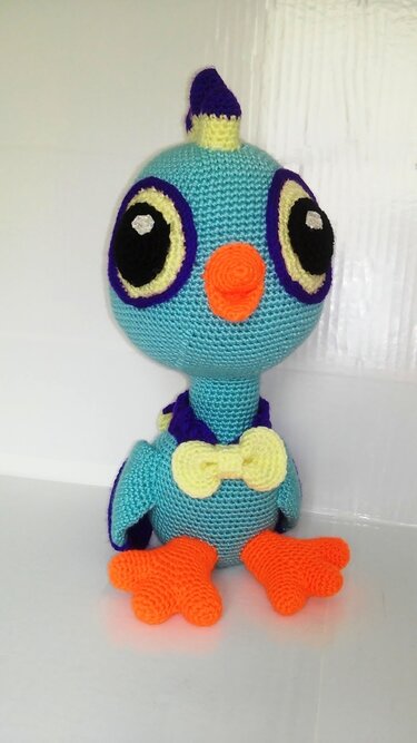 Gehäkelter türkisfarbener Amigurumi-Vogel mit großen Augen, orangeem Schnabel und Füßen