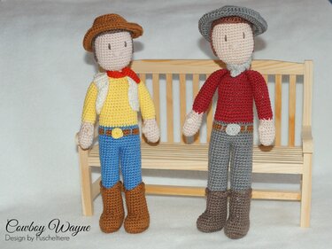 Zwei gehäkelte Amigurumi-Cowboypuppen vor einer Miniatur-Holzbank
