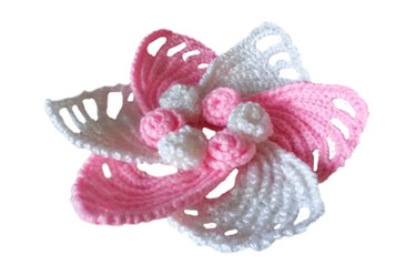 Gehäkelte Blumenapplikation in Rosa und Weiß mit offenen Blütenblättern und kleinen Mittelkugeln