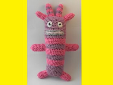 Gehäkeltes Amigurumi-Monster in Pink und Lila mit auffälligen Augen und Fühlern