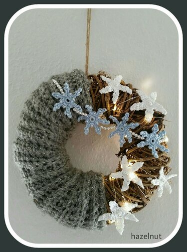 DIY Türkranz aus Reben mit grauer Häkelummantelung, gehäkelten Schneeflocken, Perlenband und warmweißer Lichterkette