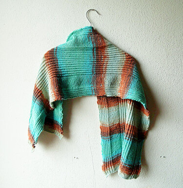 Gestricktes Rechtecktuch mit horizontalen Streifen in Türkis, Orange und Braun an einem Kleiderbügel vor heller Wand