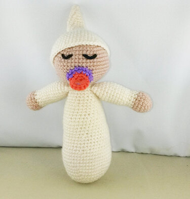 gehäkelte Babypuppe in Creme mit Zipfelmütze und buntem Schnuller