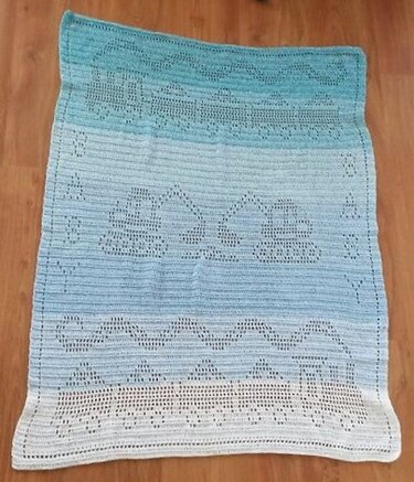 Gehäkelte Babydecke in Türkis und Weiß mit Filetmuster und wellenförmigen Motiven