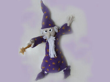Purple crocheted wizard amigurumi with pointed hat, white yarn beard and star wand