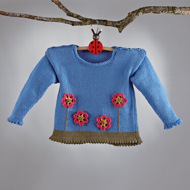 Blaue gestrickte Kinder-Tunika mit Rundhalsausschnitt, olivgrünem gezacktem Saum und pinken Häkelblumen