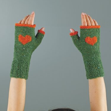 Gestrickte, fingerlose grüne Armstulpen mit orangefarbenem Herz