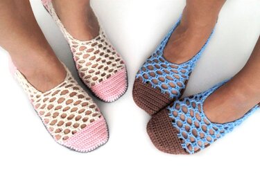 Top-down view of two pairs of feet wearing crocheted mesh slippers in cream with pink toes and blue with brown toes on a white background.