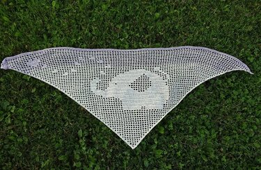 weißes gehäkeltes Dreieckstuch in Filettechnik mit Elefantenmotiv auf Gras