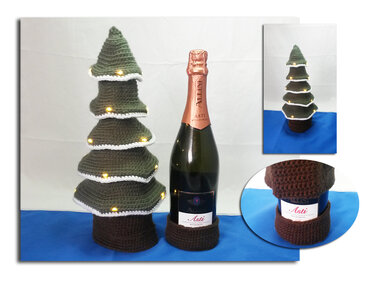 Gehäkelter grüner Weihnachtsbaum mit LED-Lichtern als Flaschenüberzug neben einer Flasche