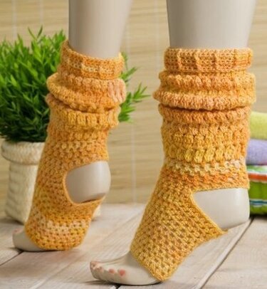 Gehäkelte Beinstulpen in Orange- und Gelbtönen mit offener Ferse an Schaufensterpuppe