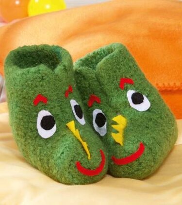 Paar grüner gefilzter Babyschuhe mit Vogelgesicht
