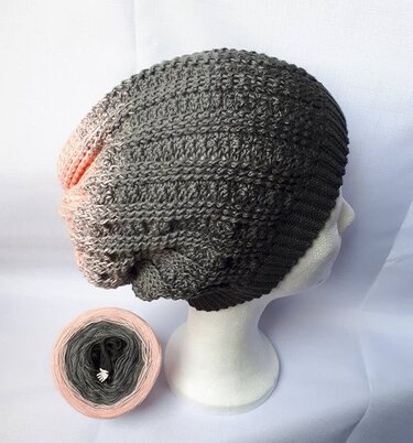 Gehäkelte Slouchy-Mütze in Rosé- und Grautönen auf Mannequinkopf mit Farbverlaufsgarn