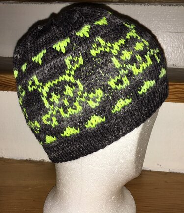Dunkelgraue Strickmütze mit neongelbem Jacquardmuster auf Kopfmodell