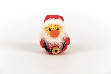 Gehäkeltes Amigurumi-Küken im roten Weihnachtsmann-Kostüm mit weißem Bart