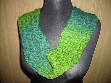 Gestrickter geschlossener Loop-Schal in Grünverlauf auf schwarzer Büste