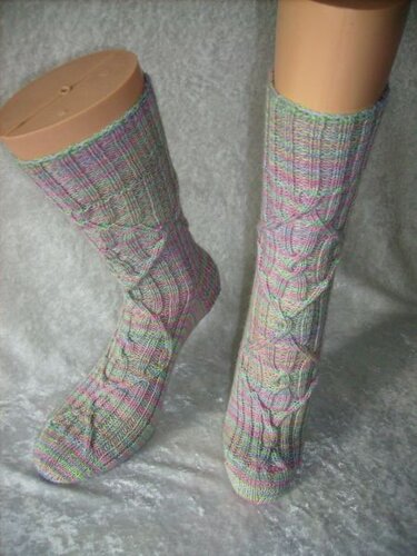 Mehrfarbige gestrickte Zopfsocken mit Zopfmuster auf Sockenpuppen