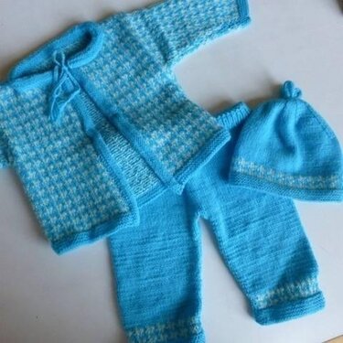 Gestricktes Babyset in Hellblau und Weiß: Jacke, Hose und Mütze.