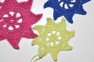 Gehäkelte Sterne in Pink, Blau und Limettengrün von oben betrachtet