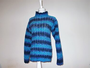 Mannequin mit langärmligem gehäkelten Pullover in gestreiften Blautönen