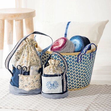 Kompakte Nähbeutel mit Außentaschen und Tragegriffen neben einem Korb mit Garnknäueln