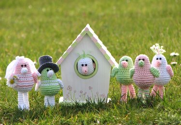 Gehäkelte Vögel als Brautpaar und Gäste vor einem Vogelhaus auf einer Wiese