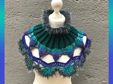 Gehäkelter Kragenschal in Grün-, Blau- und Violetttönen mit flauschiger Kante auf Schaufensterpuppe