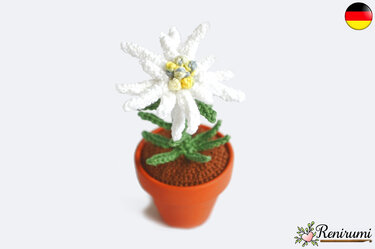 Gehäkelte weiße Edelweißblume mit gelbem Zentrum in kleinem Terrakottatopf