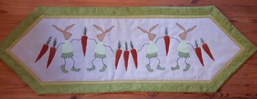Weißer Tischläufer mit grüner Bordüre und applizierten Hasen und Karotten