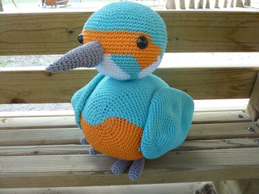 Gehäkelter Amigurumi-Vogel türkis-orange mit grauem Schnabel und schwarzen Augen