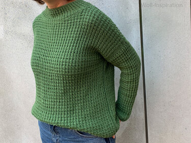 Grüner Strickpullover mit Waffelmuster und leichtem Stehkragen, kombiniert mit Jeans