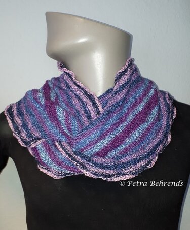 Gestrickter Loop mit diagonalen Streifen in Lila-, Blau- und Rosatönen auf einer Schaufensterpuppe