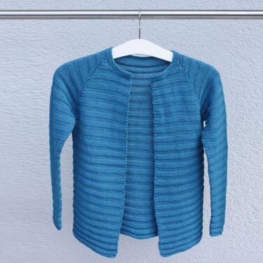 Blaue gestrickte Kinderjacke mit Rippenstruktur an einem Kleiderbügel