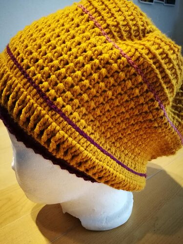 Gehäkelte Beanie in Senfgelb mit lila Streifen auf Styroporkopf