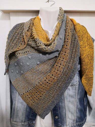 Gestricktes Dreieckstuch grau-gelb mit Noppen- und Lochmuster auf Jeansjacke