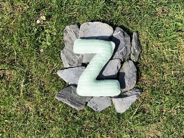 Gefüllter gehäkelter Buchstabe Z in Mint auf Schiefersteinen im Gras
