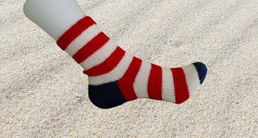 Knöchelhohe Stricksocke mit rot-weißen Querstreifen und dunkelblauer Ferse