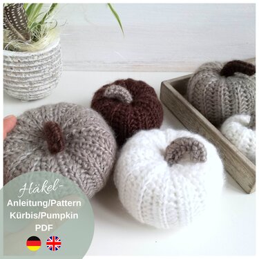 Finished small crocheted pumpkins in neutral tones (beige, brown, white) with a visible label for a PDF crochet pattern.