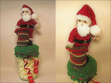 Gehäkelter Weihnachtsmann mit roter Mütze und Bart auf grünem Deckelbezug auf einem Glas mit Süßigkeiten.