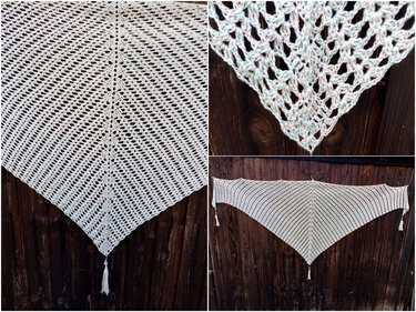 Hellfarbenes gehäkeltes Dreieckstuch mit Lochmuster und Quasten vor dunklem Holz