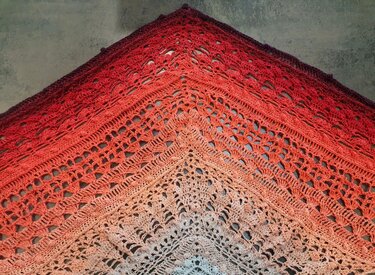 Gehäkeltes Dreieckstuch in Ombre-Verlauf von Creme, Pfirsich bis Rot mit detailliertem Lochmuster