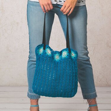 Türkis‑blaue gehäkelte Henkeltasche mit schwarzen Trägern und runden Ziermotiven
